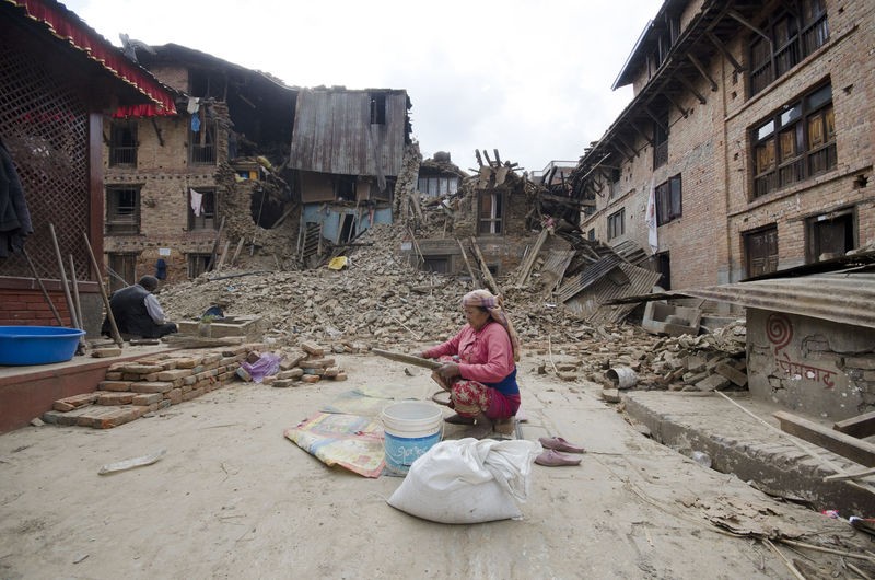 この女性は米粒を粉塵や砂利からより分けていた。4月25日にネパールを襲ったマグニチュード7.8の地震で、家だけでなく、蓄えてあった家族の食糧も破壊されたからだ。カトマンズの約8km南、ブングマティ村にて。著作権　Demotix（2015/4/27）