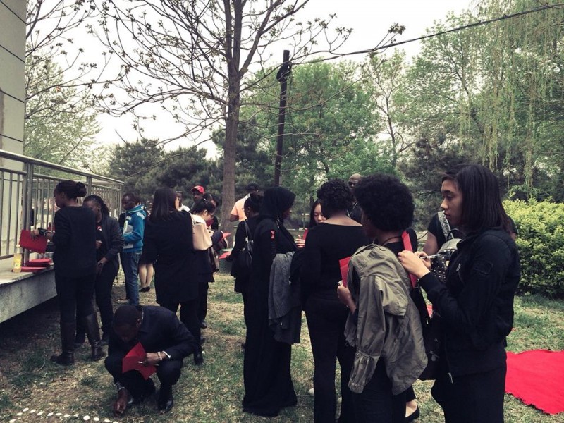 Around 70 African students gather near an entrance of the park to join the vigil. 