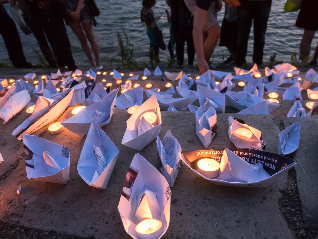 Hungarian protesters launch paper boats made out of pages of the biased questionnaire, to represent the lost lives of illegal migrants. Photo by Anna Vörös, courtesy of MigSzol Facebook page, used with permission.