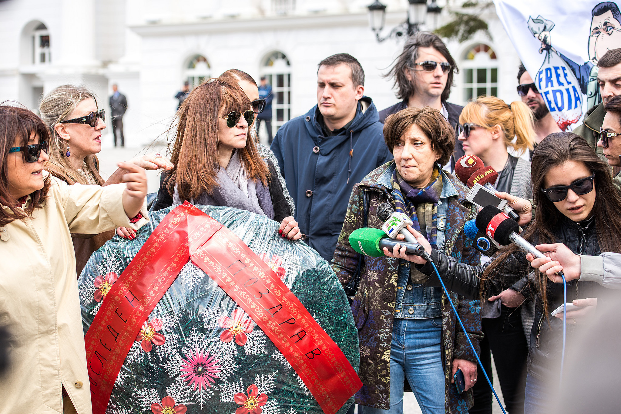 Неколку новинари дадоа изјави на протестот во Скопје во врска со смртните закани упатени кон новинарот Борјан Јовановски, држејќи го погребалниот венец кој беше доставен во неговиот дом како смртна закана во Април 2015 година. Слика на Ванчо Џамаски, преземена со дозвола.