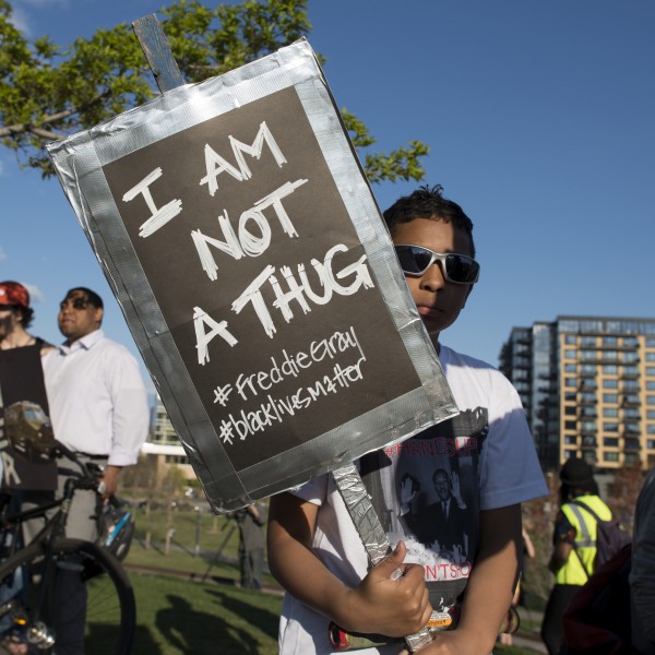 A young man holds up a placard during the Minneapolis rally to support the people of Baltimore. Photo by Fibonacci Blue, used under a CC BY 2.0 license.  