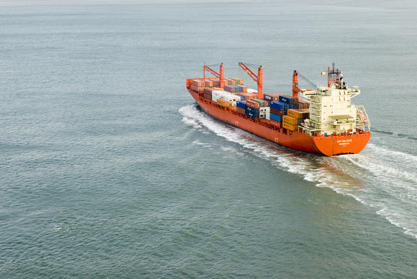 A large cargo ship full of shipping containers sailing into port. Photo: stockarch.com 