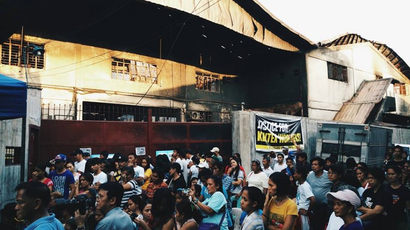 Kentex workers, relatives of the fire victims, and supporters hold a vigil in front of the factory during the May 18 "National Day of Mourning". Photo Credits: Vencer Crisostomo