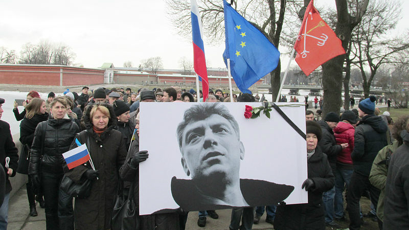 Boris Nemtsov was murdered in February 2015  before he could finish the report on the war. His photo is seen here at a memorial rally in St. Petersburg on March 1, 2015. Image from Wikimedia Commons.