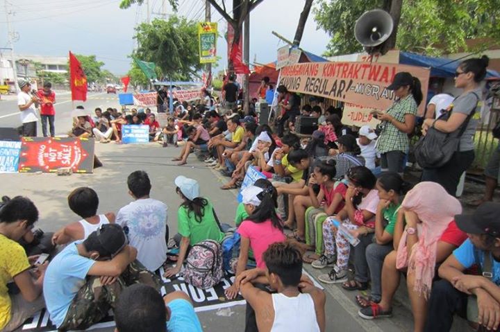 Striking workers hold program at the picket line with their families and supporters. Photo Credits: Kilusang Mayo Uno.