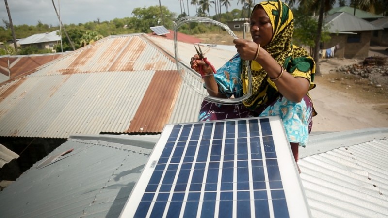 Mize Juma Othman, de 40 años, instala un panel fotovoltaico en una casa de Matemwe, en la isla tanzana de Zanzíbar. Othman se formó durante seis meses en India para convertirse en una de las 13 primeras «mamás solares» de Zanzíbar, capaces de instalar, reparar y mantener estos sistemas. Foto de Sam Eaton, publicada con autorización
