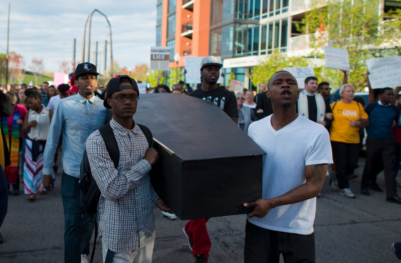 Demonstrators carry a mock coffin at a march in Minneapolis condemning police killings of black men and women. Photo by Fibonacci Blue via Flickr (CC BY-2.0)
