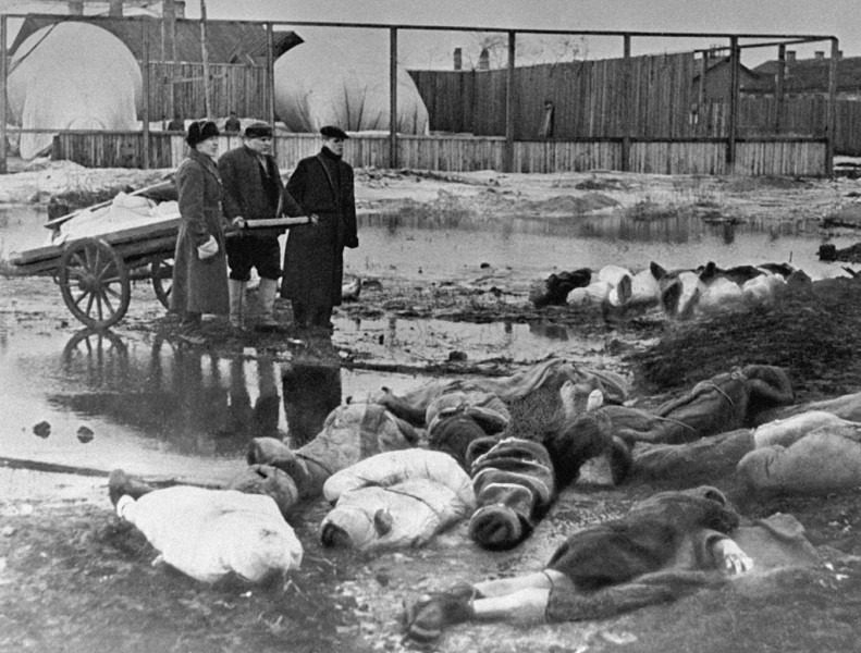 Tři muži pohřbívají mrtvé během obléhání Leningradu v roce 1942, hřbitov Volkovo. Boris Kudojarov, RIA. Publikováno v souladu s licencí.