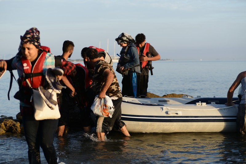 Kos, Greece. 15 August 2015 -- Syrian migrants arriving on an overcrowded dinghy along the coast of the Greek island of Kos at Psalidi beach near to the luxury hotel complexes of the island. Photo by Wassilis Aswestopoulos. Copyright Demotix 