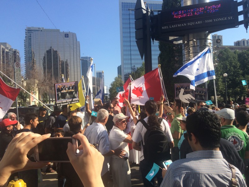 Anti-deal supporters waving Canadian, Israeli and IDF flags encircle the start of the #SupportIranDeal rally in Toronto. Photo by author.