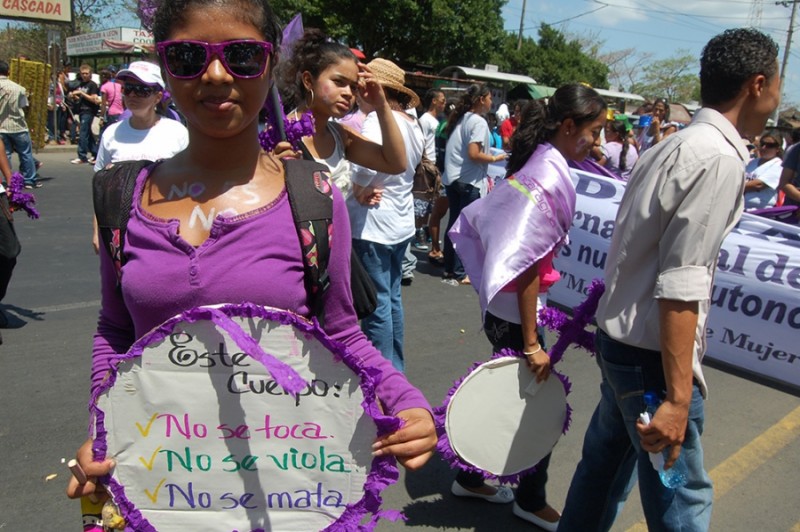 A young activist marches on International Women’s Day in 2012 with a sign that reads, “This body will not be touched, will not be raped, will not be murdered.”  Since Law 779 was passed in 2012, it has been modified to allow mediation. Credit: Sara Van Note. Used with PRI's permission